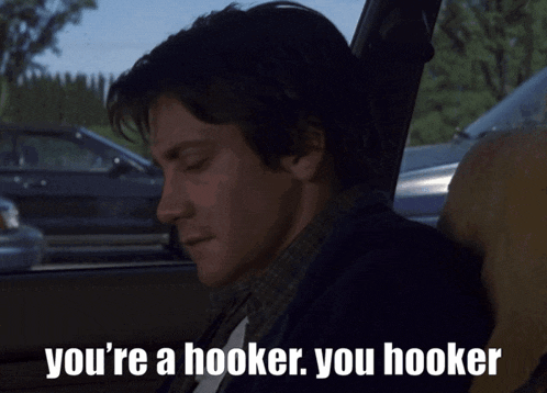 a man sitting in a car with the words you 're a hooker you hooker