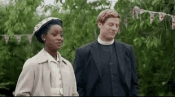 a man and a woman are standing next to each other in a field .