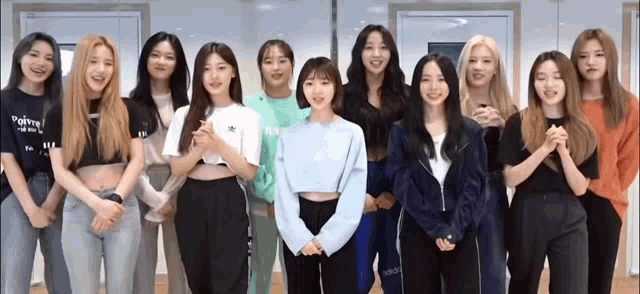 a group of young women are standing next to each other in a room and smiling .