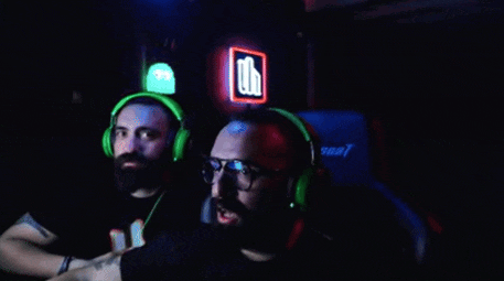 two men wearing green headphones and glasses are playing a video game