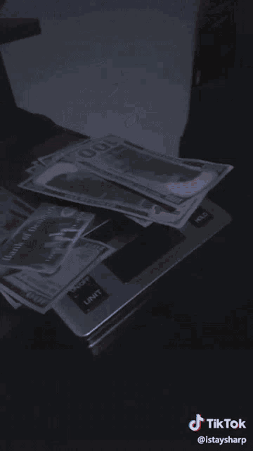 a stack of 100 dollar bills on top of a black surface