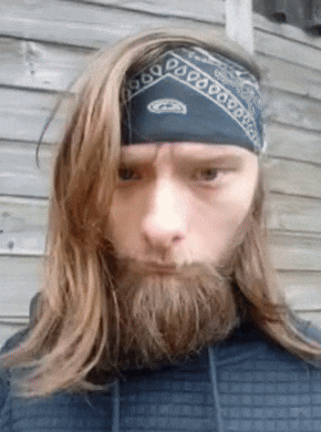 a man with long hair and a beard is wearing a bandana on his head
