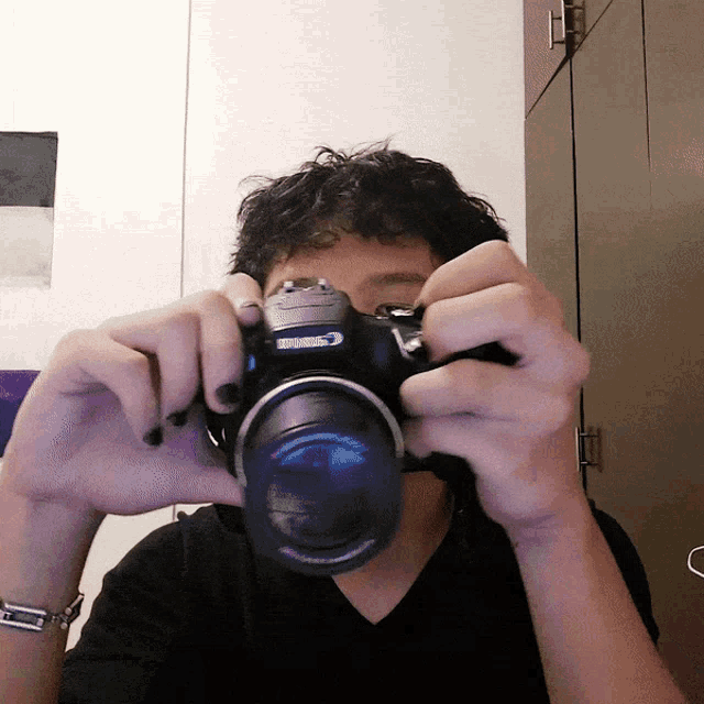 a man is taking a picture with a canon brand camera