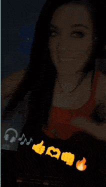 a woman wearing headphones and a red tank top smiles while playing music