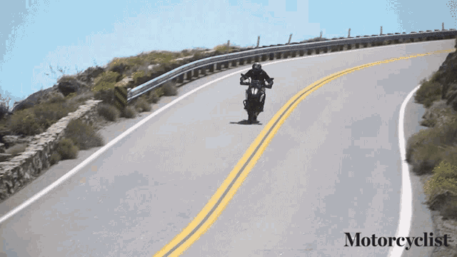 a person riding a motorcycle down a road with the word motorcyclist on the bottom