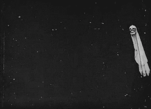 a black and white photo of a ghost with a skull on its head flying through the air .