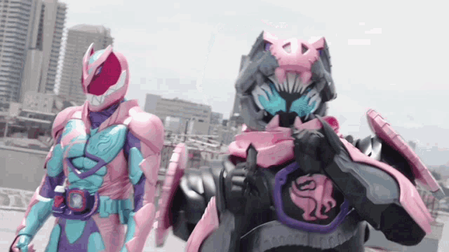a man in a pink and purple costume is standing next to another man in a purple and pink costume .