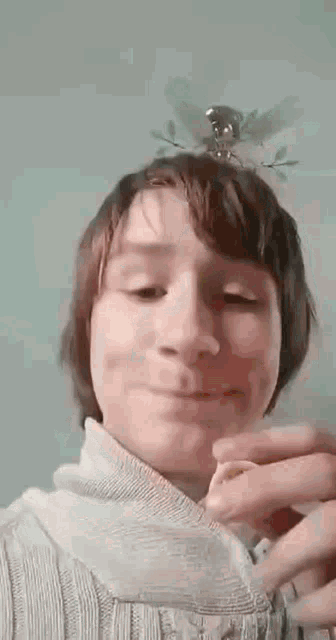 a young boy is making a funny face while holding a piece of food in front of his face .