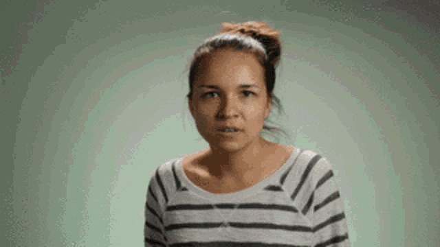 a woman wearing a striped shirt looks at the camera