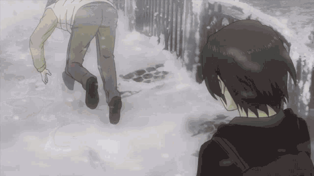 a man is walking in the snow while another man looks on