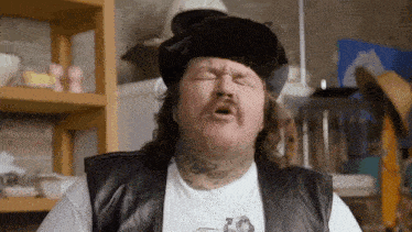 a man with a tattoo on his neck is wearing a hat