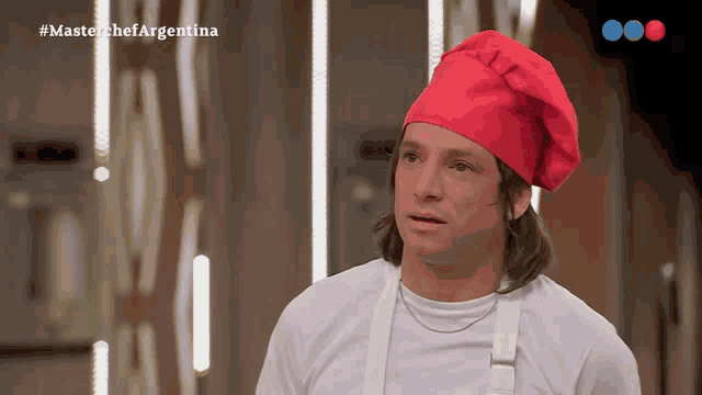 a man wearing a red chef 's hat is on a master chef argentina show