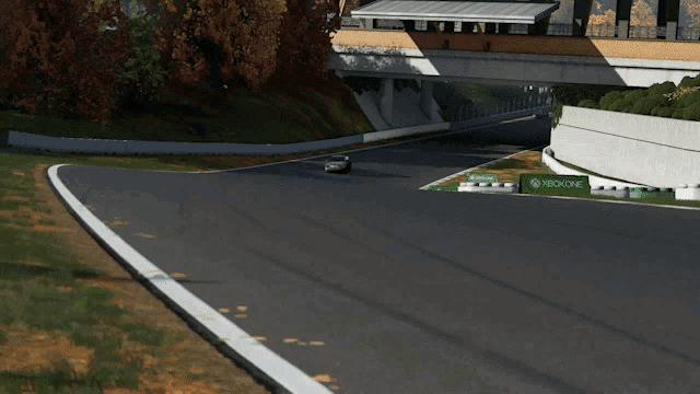 a silver car is driving down a road in front of a sign that says ' toyota '