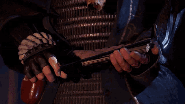 a man with his eyes closed holds a sword