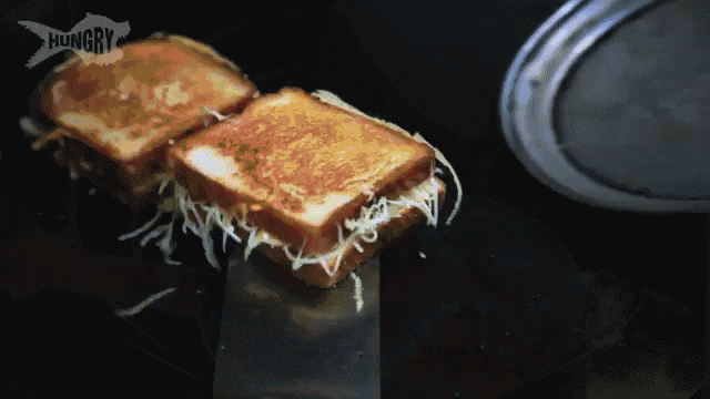 two grilled cheese sandwiches are being cooked in a pan with the word hungry on the bottom