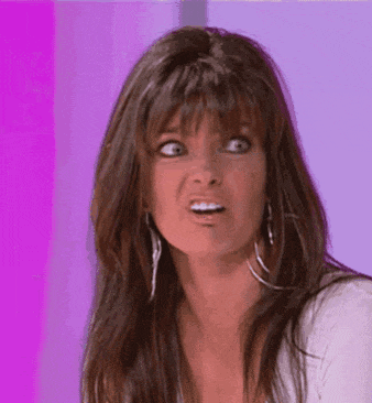 a woman with long brown hair is making a funny face .