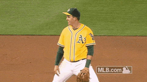a baseball player wearing a yellow a's jersey