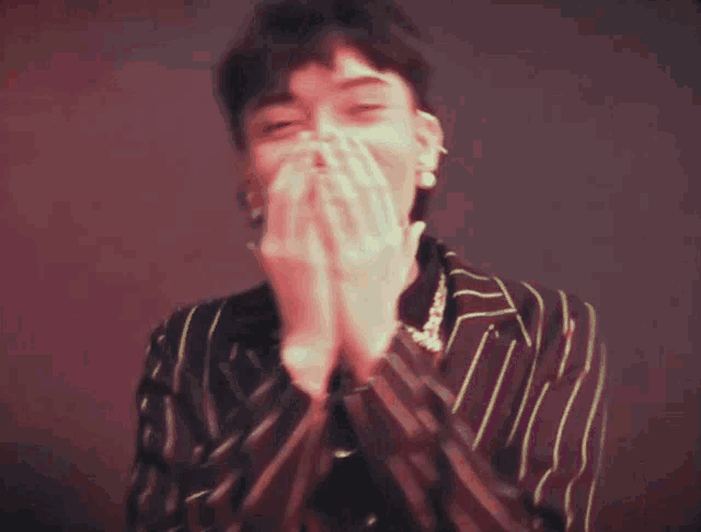 a young man covering his mouth with his hands