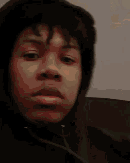 a man in a hoodie is holding a green light in his hand .