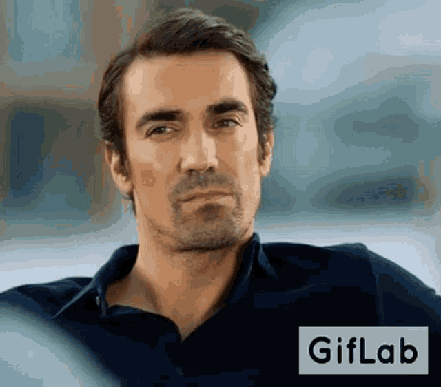 a man with a beard is sitting in front of a gif lab logo