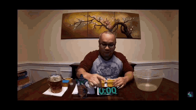 a man sits at a table with a clock that reads 0:00