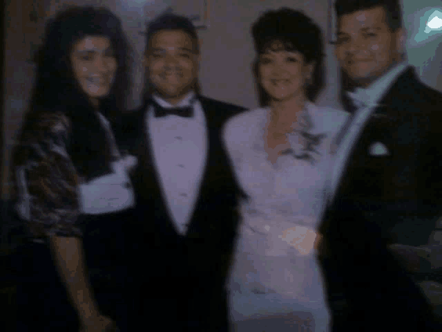 a bride and groom are posing for a picture with their parents .