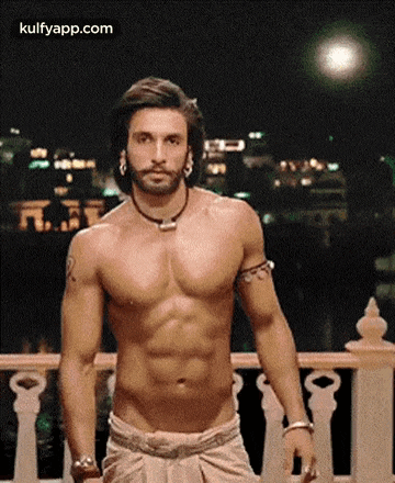 a shirtless man is standing on a balcony with his arms outstretched .