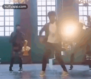 a man is dancing in a room with a group of people .