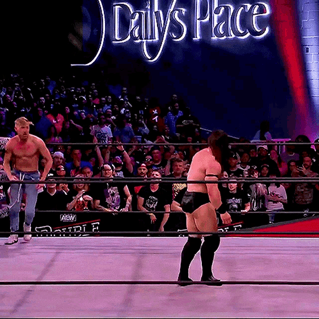 a man in a wrestling ring with a sign that says daily 's place