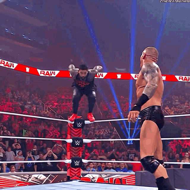 a wrestling match is going on in front of a crowd and a referee ..