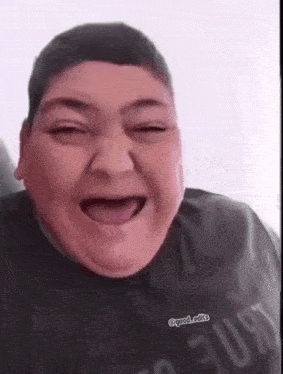 a fat man is making a funny face with his tongue out .