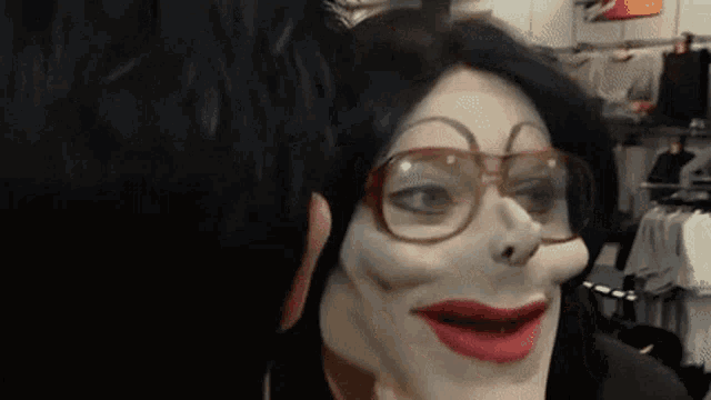 a person wearing a mask and glasses looks at another person 's face