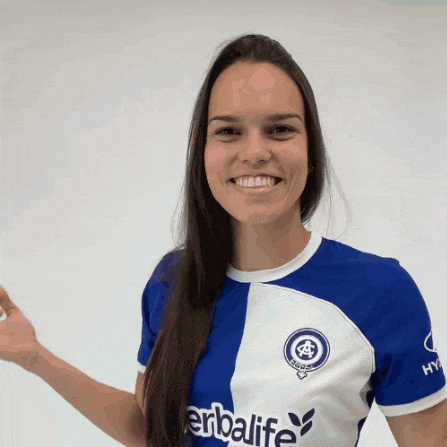 a woman in a blue and white herbalife shirt smiles