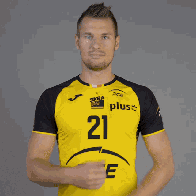 a man wearing a yellow and black pge shirt