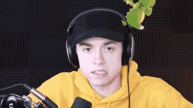 a man wearing headphones and a hat making a funny face .