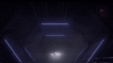 a dark room with a few lights shining through the ceiling