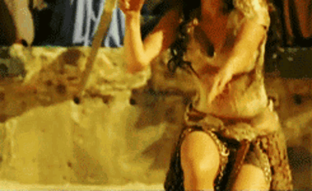 a woman in a costume is holding a stick and dancing