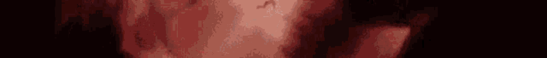 a blurry picture of a person 's face with a red and black background