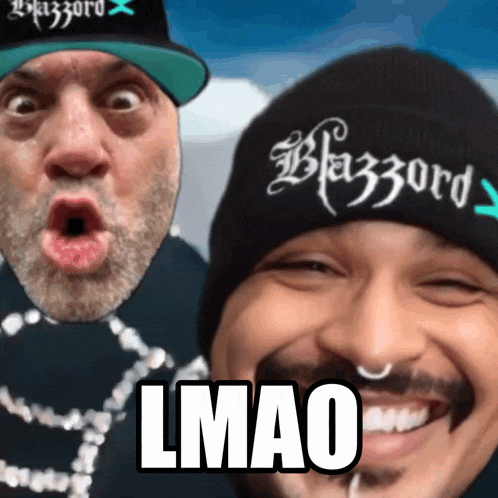 two men are posing for a picture and one has a beanie that says blazzard on it