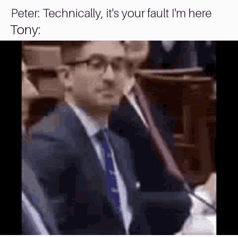 a man in a suit and tie is sitting in front of a microphone in a courtroom .
