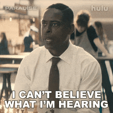 a man in a white shirt and brown tie says i can 't believe what i 'm hearing