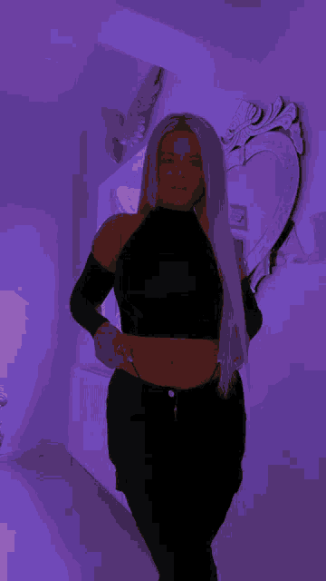 a woman in a black crop top is standing in front of a mirror