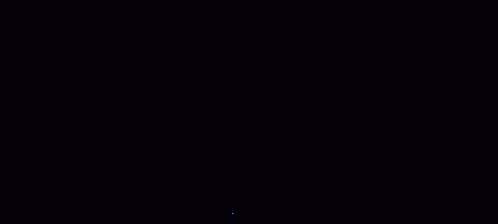 a woman is dancing in front of a microphone in a dark room with blue lights behind her .