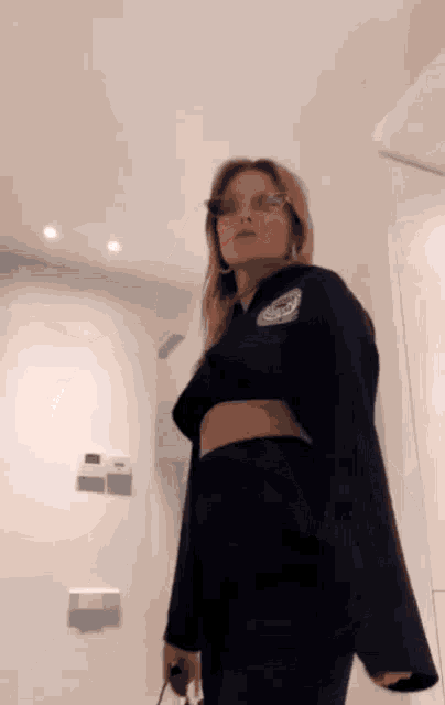 a woman wearing sunglasses and a black jacket has a patch on her shoulder that says ' a '