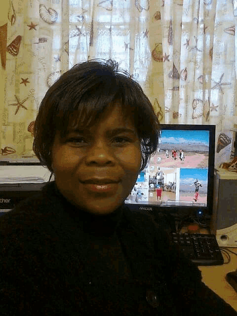 a woman sits in front of a brother computer