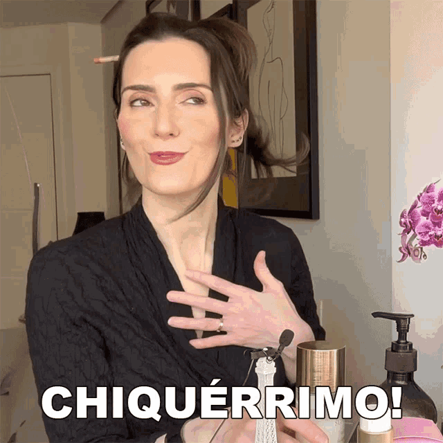 a woman holds a bottle of perfume and says " chiquerrimo " in white letters