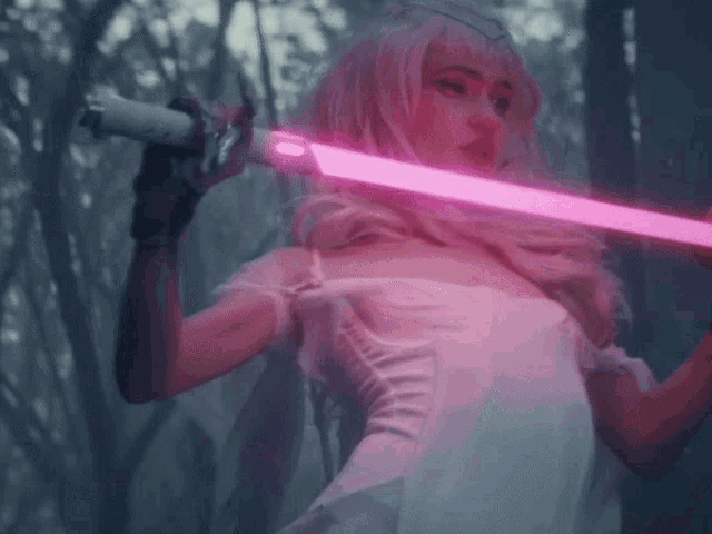 a woman in a white dress is holding a pink light sword