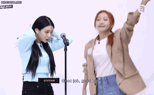 two girls are standing in front of a microphone and one of them says good job good job