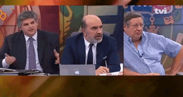 three men sitting in front of a tv screen