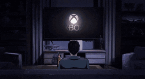a man is sitting on a couch watching a video game on a television